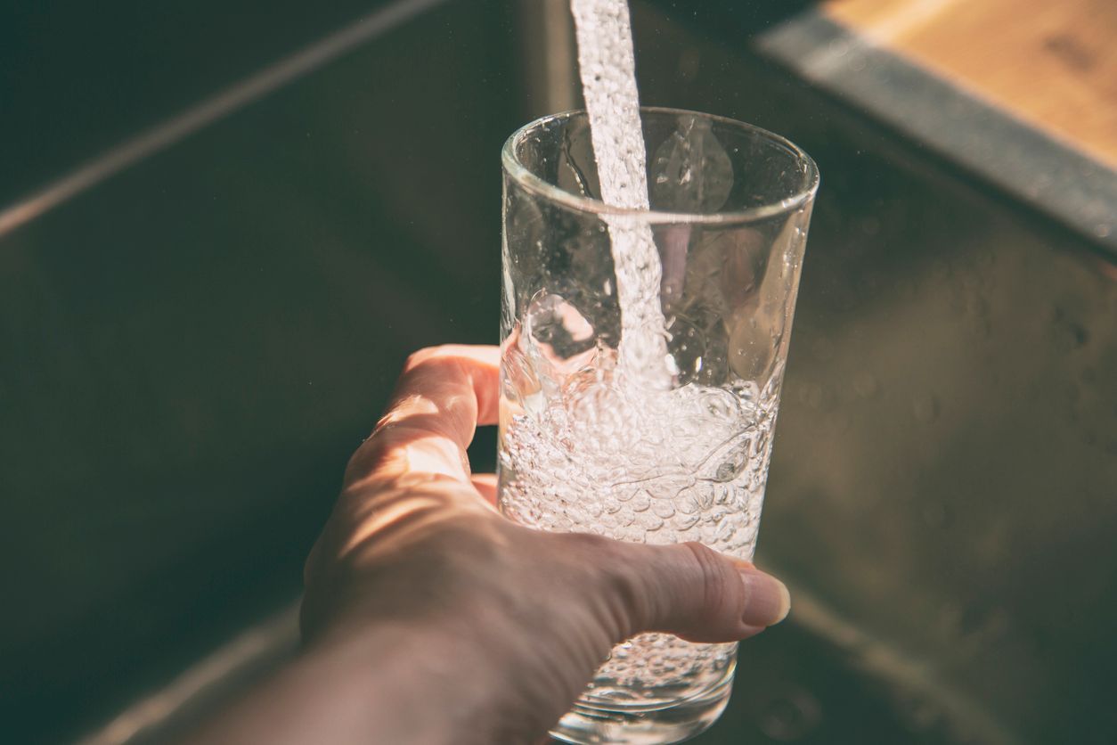 water pouring into a glass from the faucet