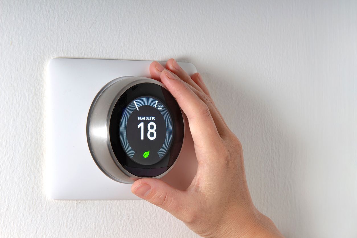 someone adjusting a smart thermostat