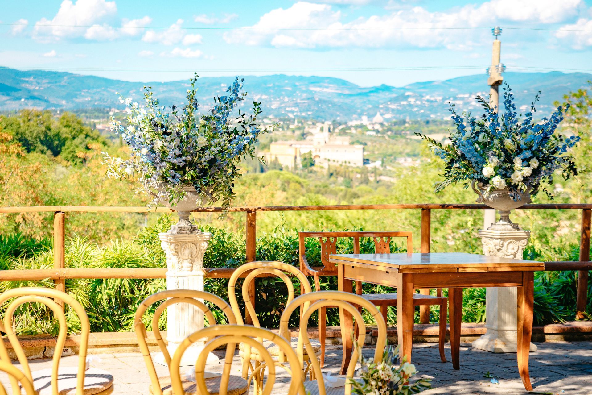 Een tafel en stoelen staan ​​klaar voor een huwelijksceremonie met uitzicht op de bergen.