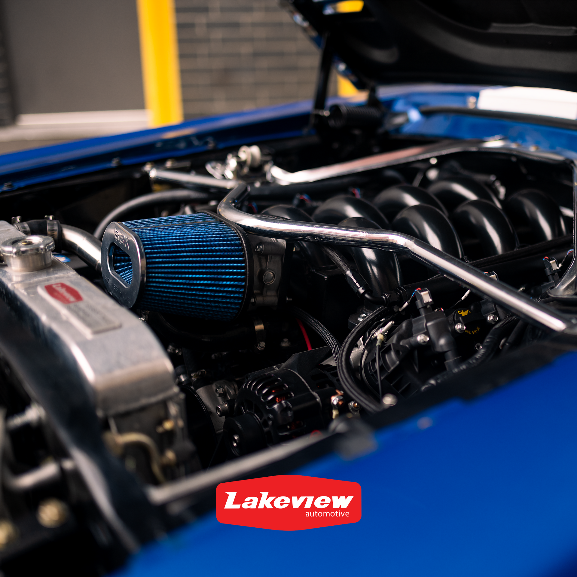 a blue 67 mustang with the hood open and a 7.3 godzilla engine has a lakeview sticker on it