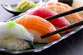 Une assiette de sushi avec des baguettes sur une table.
