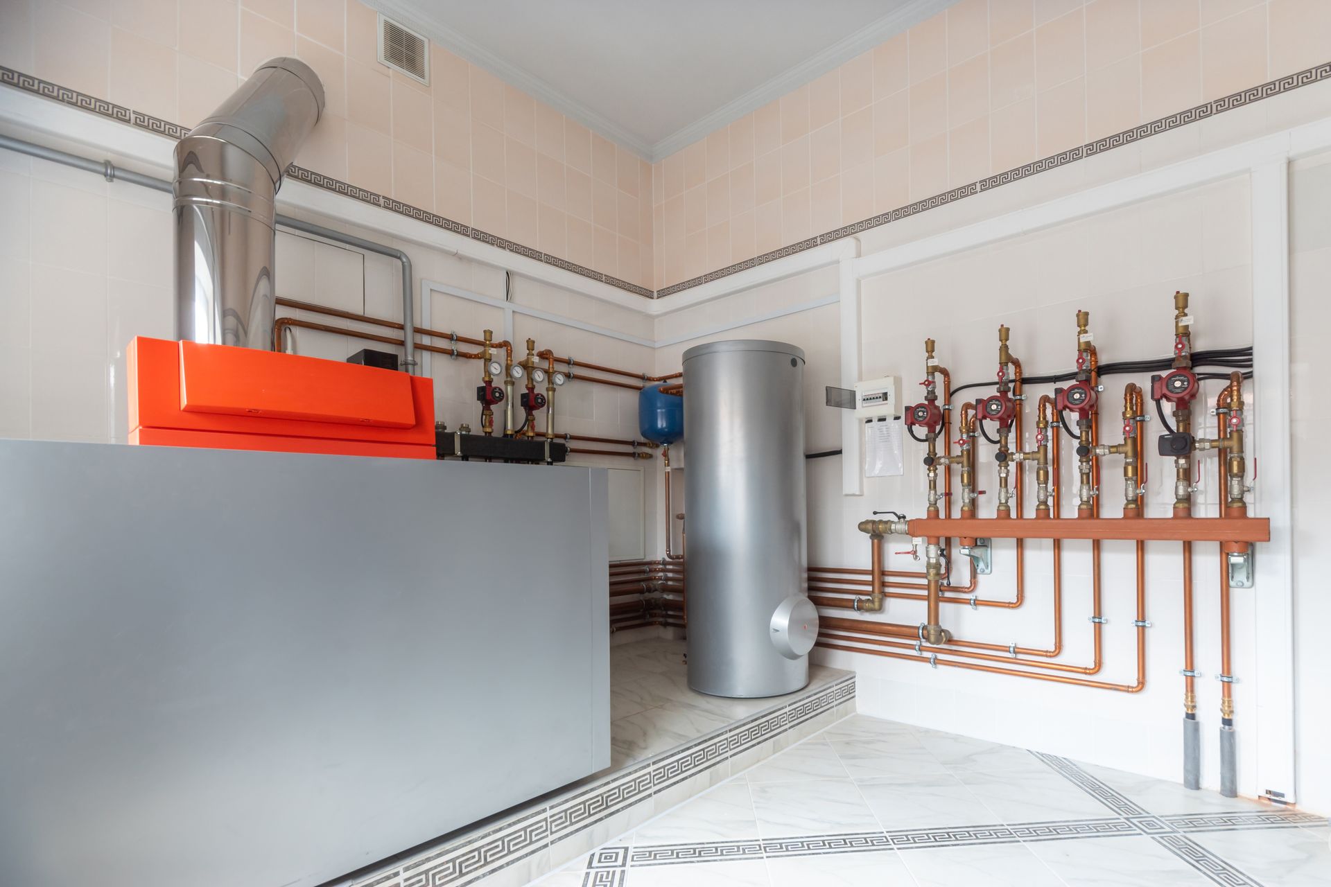 A room with a boiler and pipes in it.