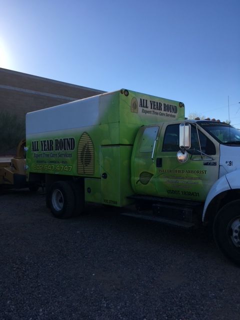Green All Year Bound service truck with a white top parked on asphalt.