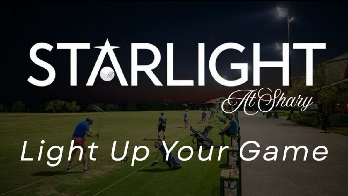 Golfer swinging at a golf ball on a driving range, with other golfers and trees in the background.