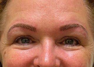 A close up of a woman 's face with green eyes and red cheeks.