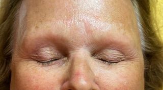 A close up of a woman 's face with her eyes closed.