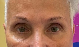 A close up of a woman 's face with green eyes.