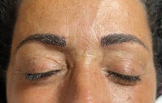 A close up of a woman 's face with her eyes closed.