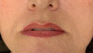 A close up of a woman 's lips with red lipstick.