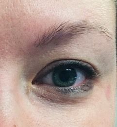 A close up of a woman 's eye with a green pupil.