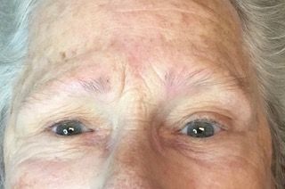 A close up of an elderly woman 's eyes and forehead.