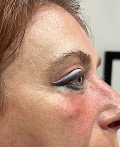 A close up of a woman 's face with eyeliner on her eye.