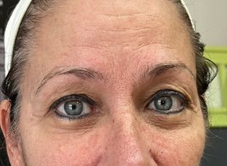 A close up of a woman 's face with blue eyes.