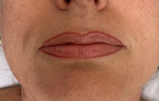 A close up of a woman 's lips with a tattoo on them.