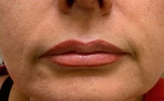 A close up of a woman 's lips with a tattoo on them.