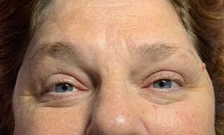 A close up of a woman 's face with blue eyes.