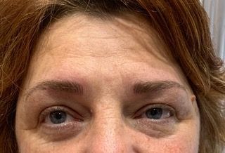 A close up of a woman 's face with blue eyes and red hair.