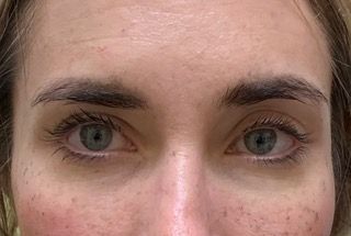A close up of a woman 's face with green eyes and freckles.