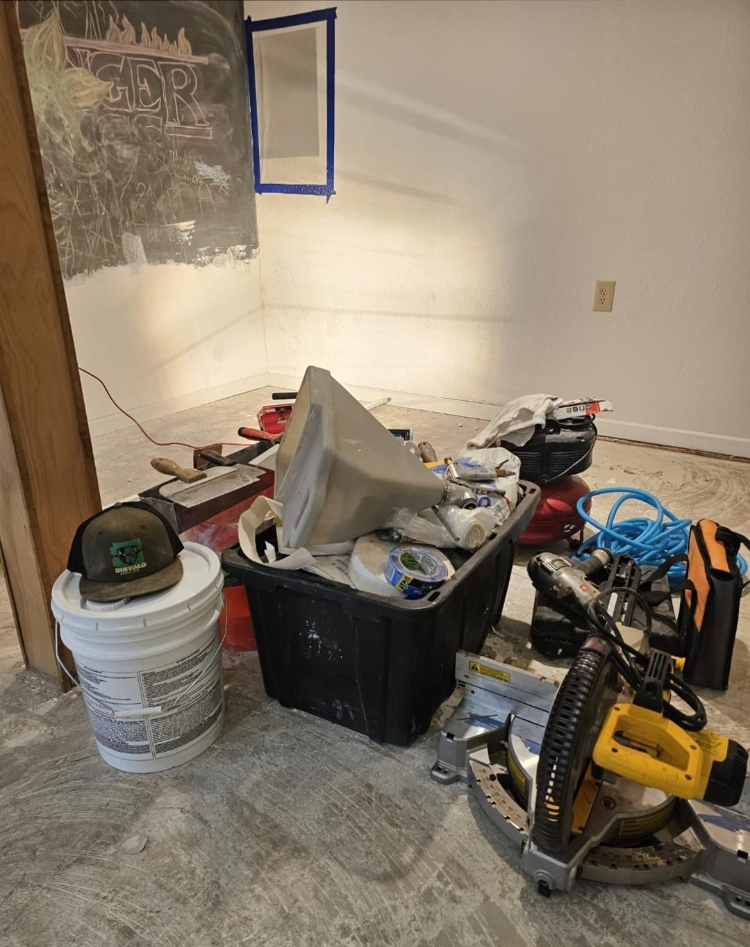 A bunch of tools are sitting on the floor in a room.