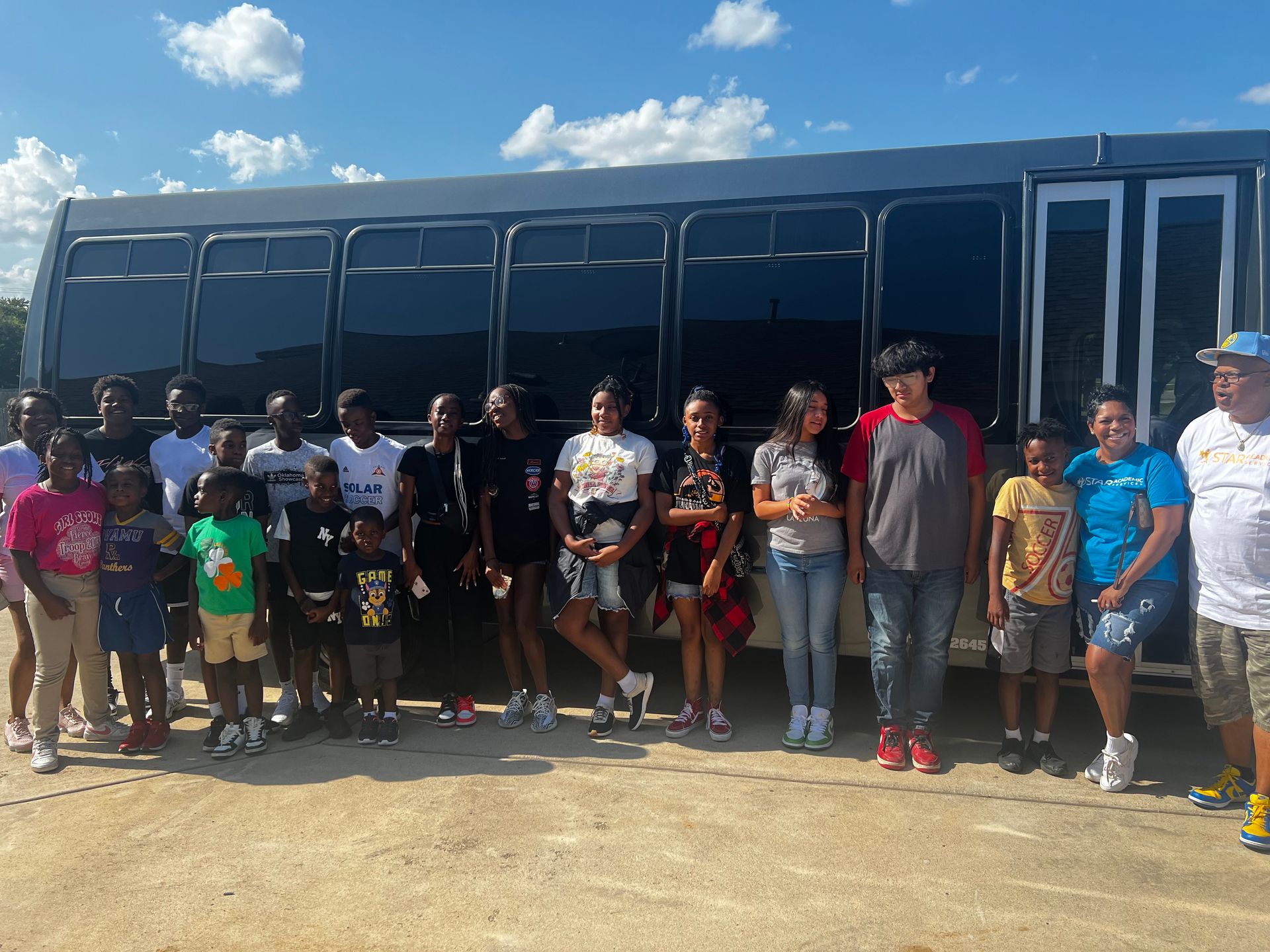 A group of people are standing in front of a bus.