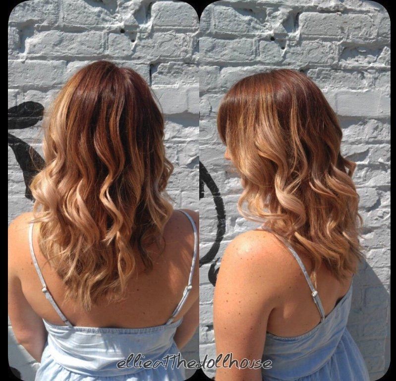 A woman in a blue dress is standing in front of a brick wall
