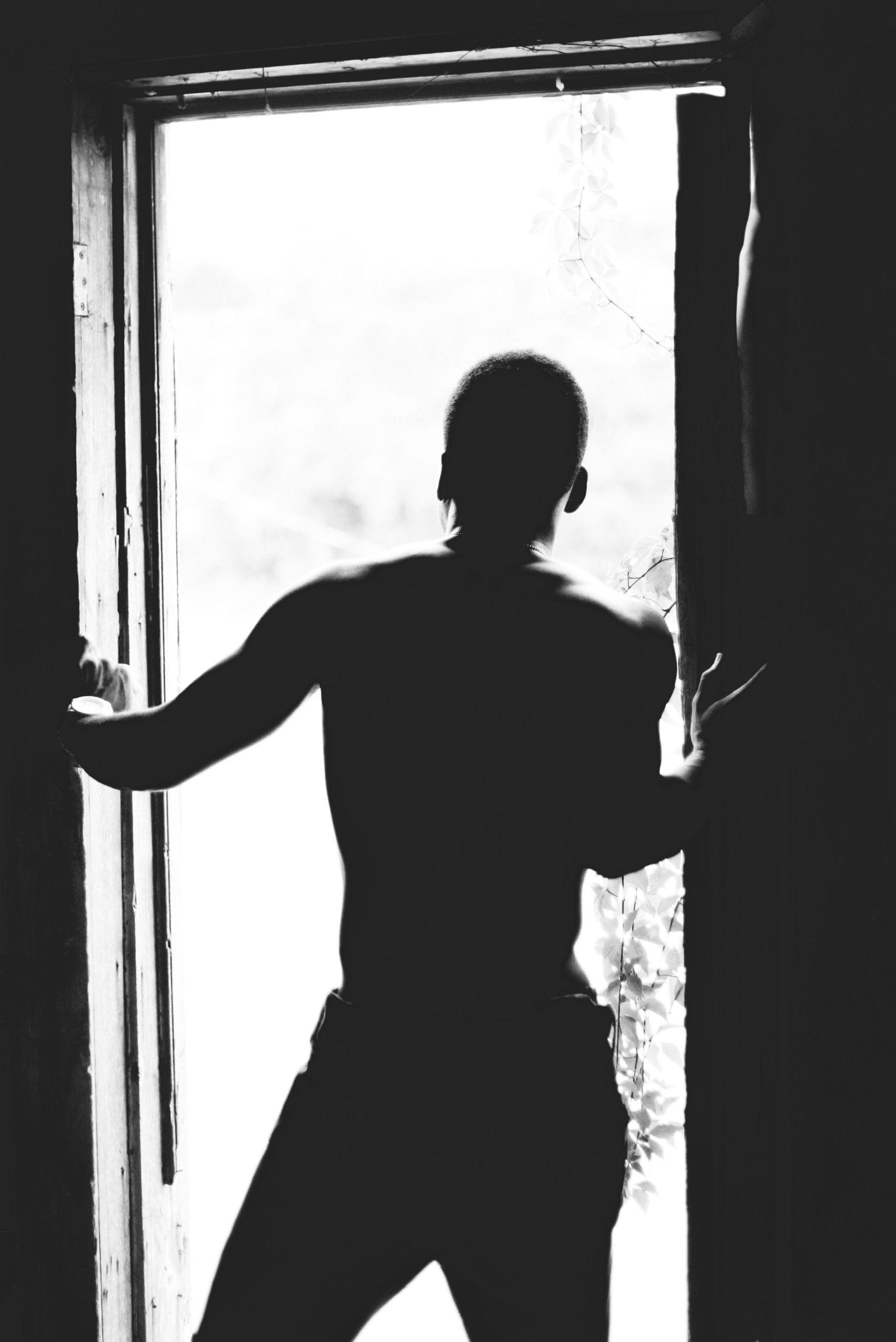 A silhouette of a man standing in an open doorway