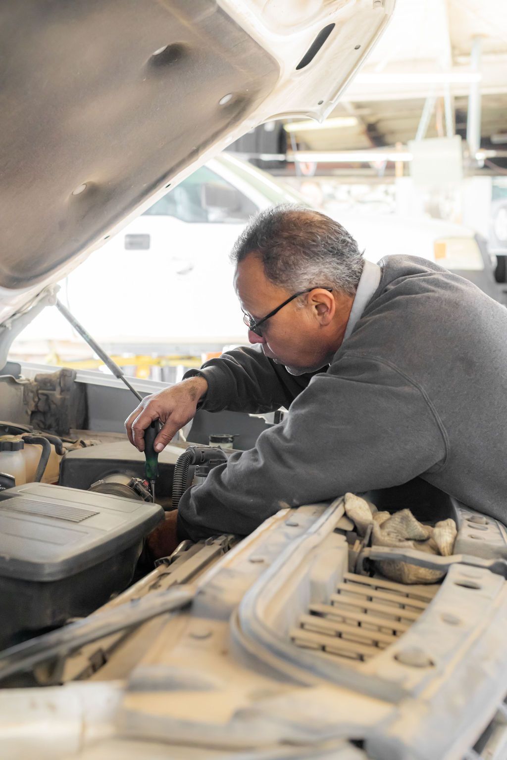 A man is working under the hood of a car