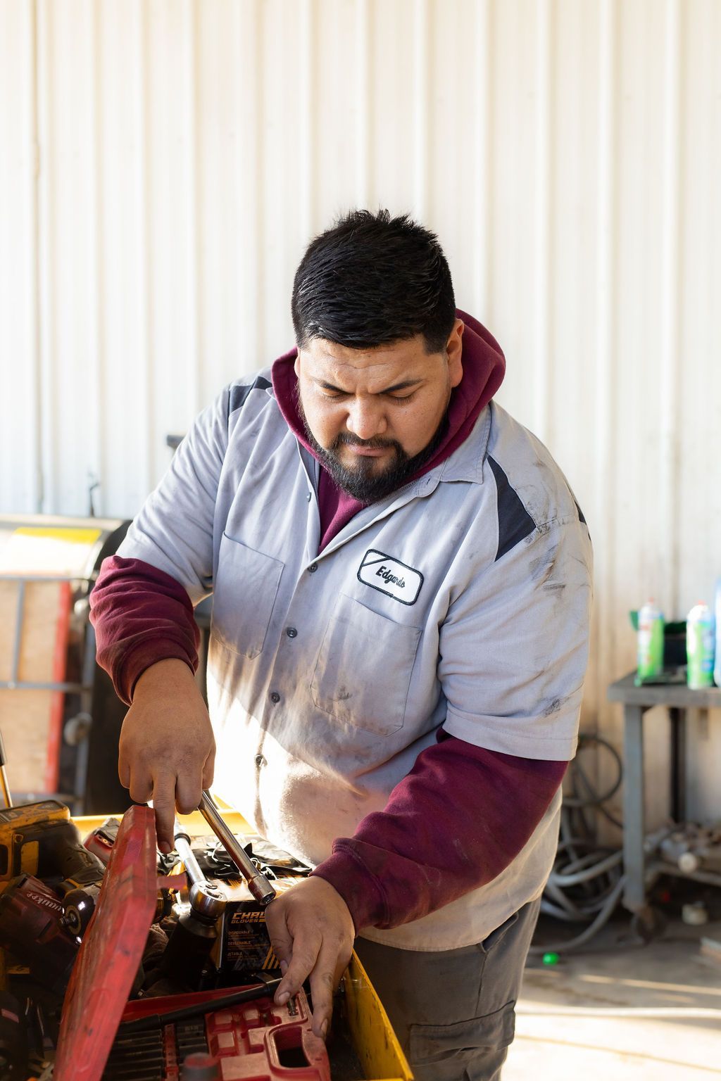 A man in a gray shirt is working on a machine