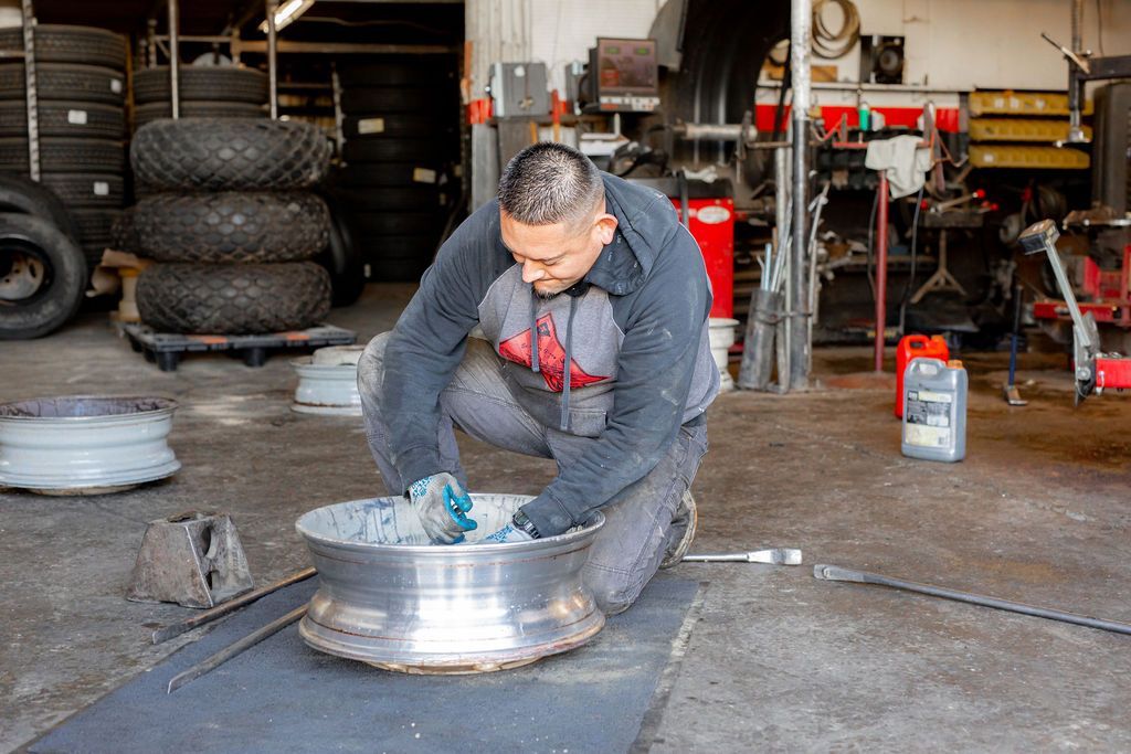 A man is working on a wheel in a garage