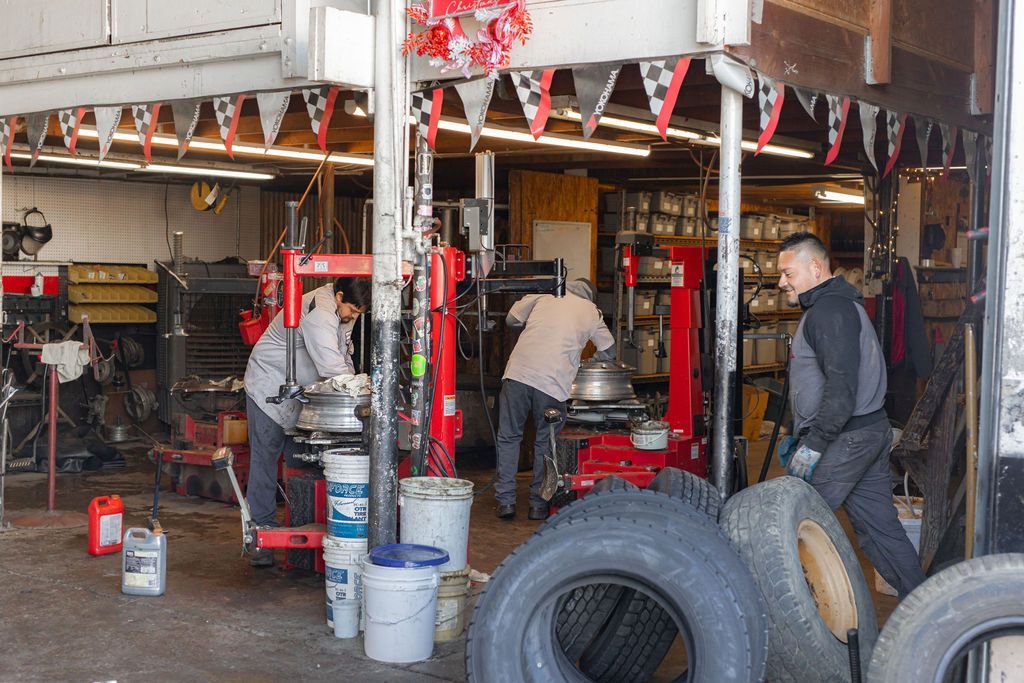 A man is working on a tire in a tire shop