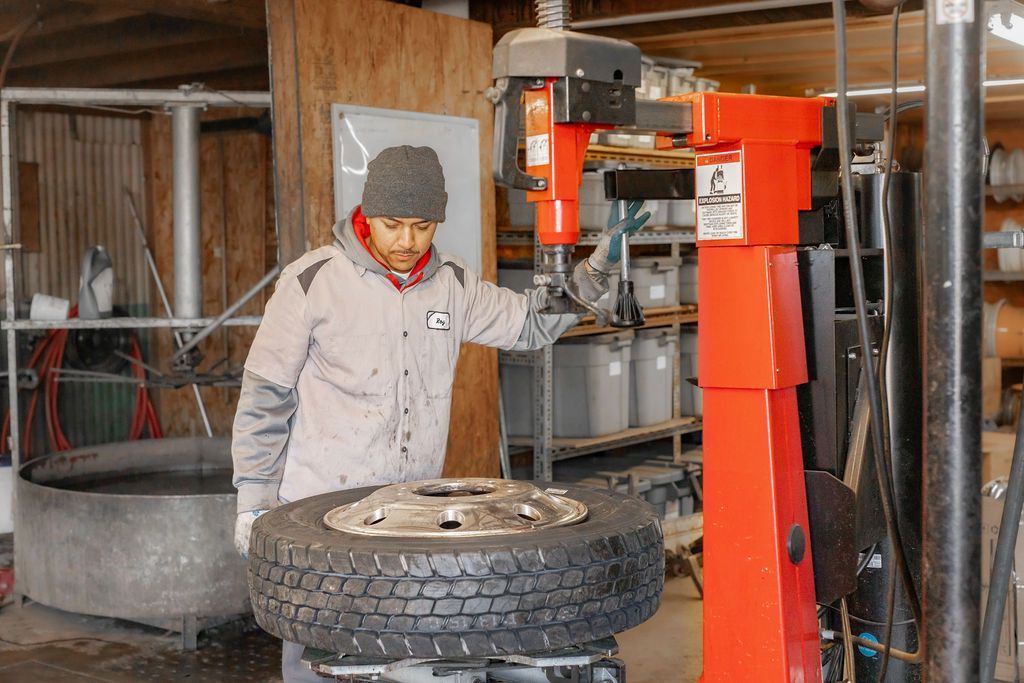 A man is working on a tire in a garage