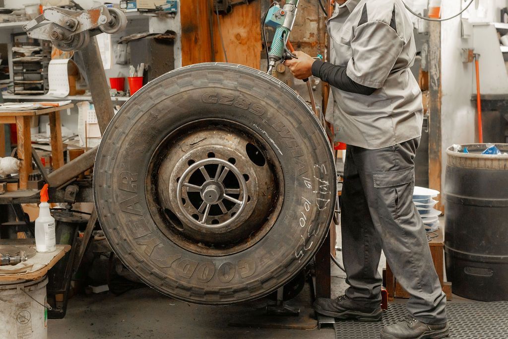 A man is working on a tire in a garage