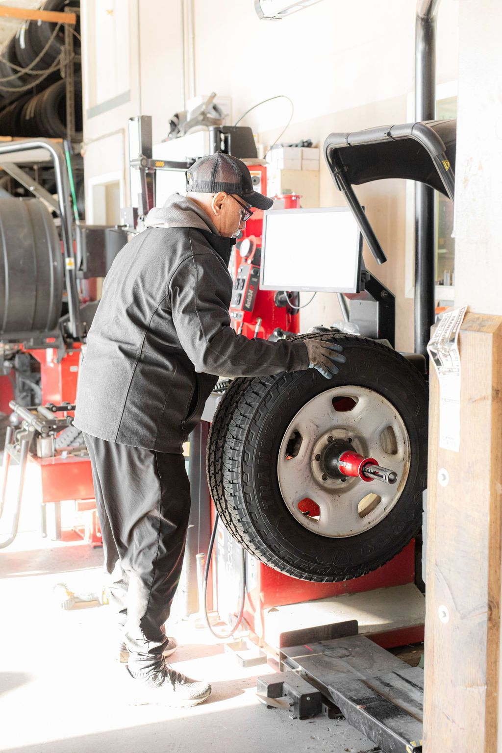 A man is working on a tire in a garage