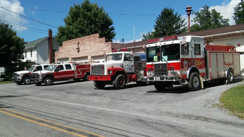 Fire trucks parked outside a fire station on a sunny day.