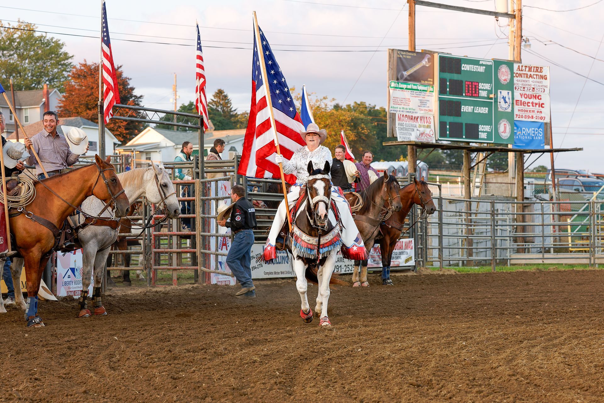 A woman is riding a horse in a rodeo arena