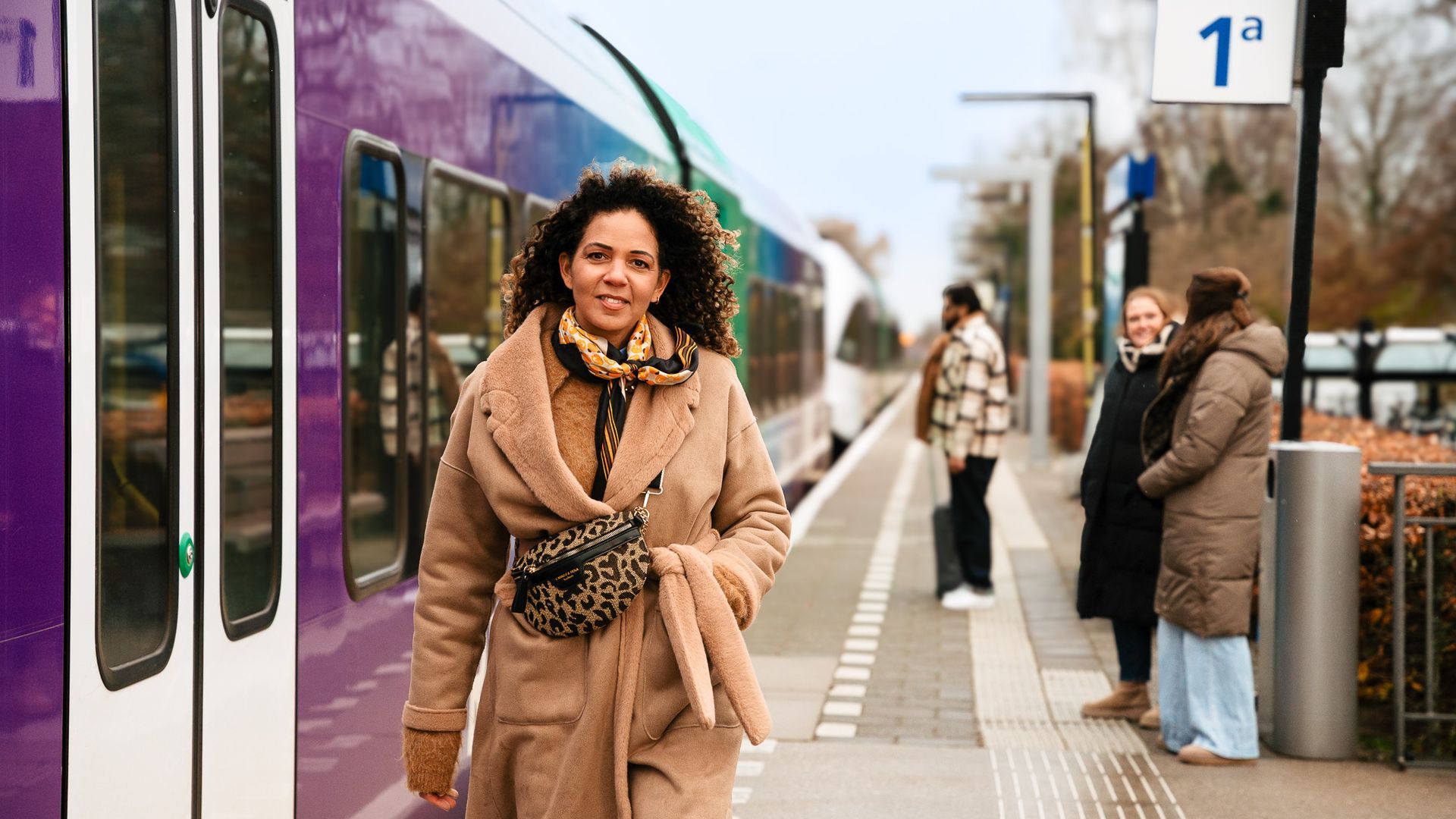 Een dame loopt over het perron op een station