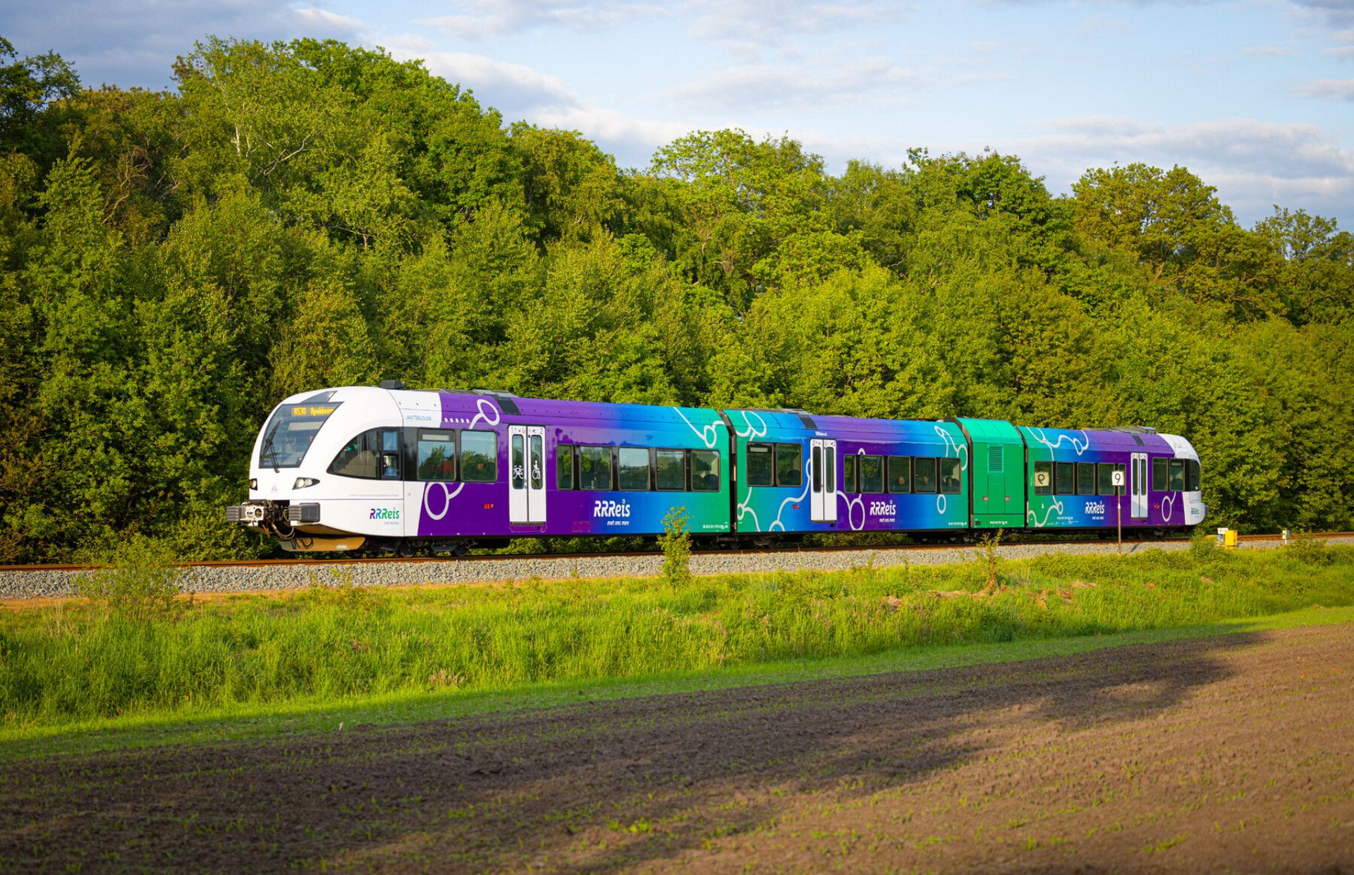 dame zit in treincoupe en werkt op haar laptop