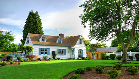 A white house with a brown roof and blue shutters