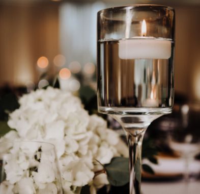 A candle is floating in a glass of water