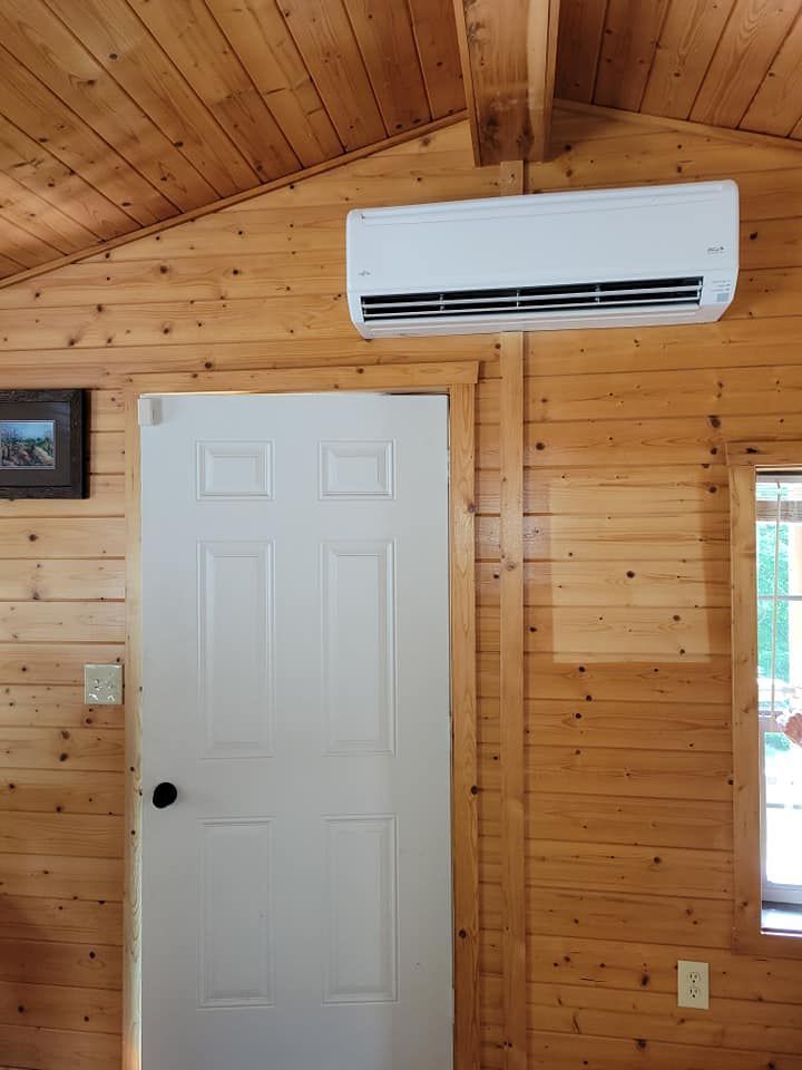A room with a white door and a white air conditioner hanging from the ceiling.