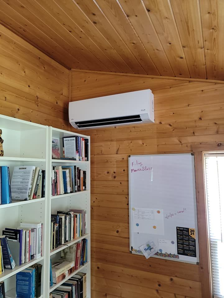 A room with bookshelves and a white board on the wall