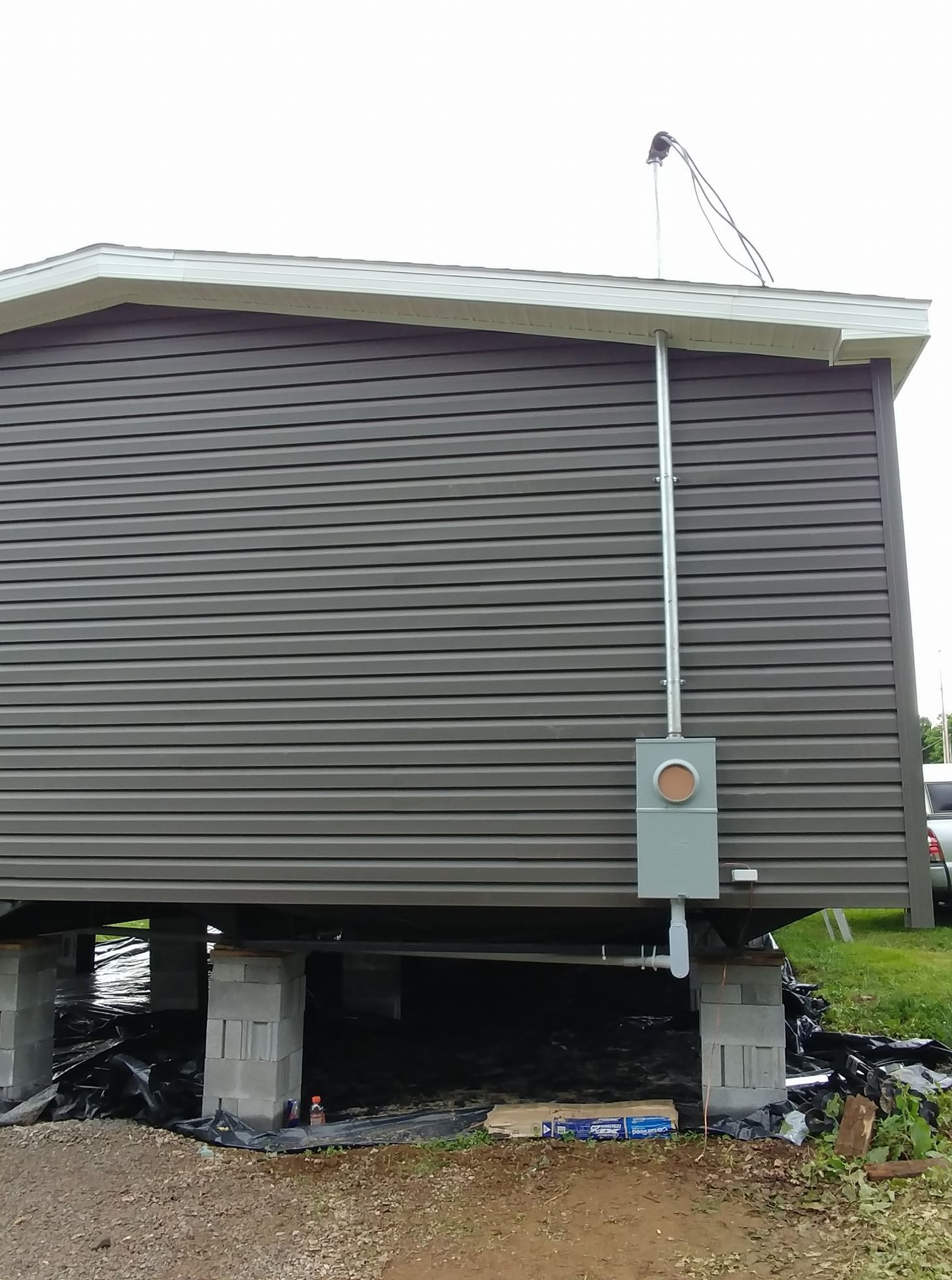 A mobile home is sitting on top of concrete blocks next to a road.
