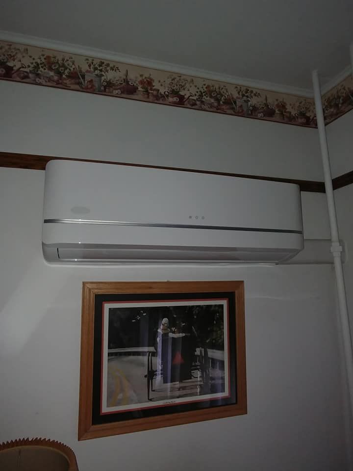 A picture on a wall next to a wall mounted air conditioner