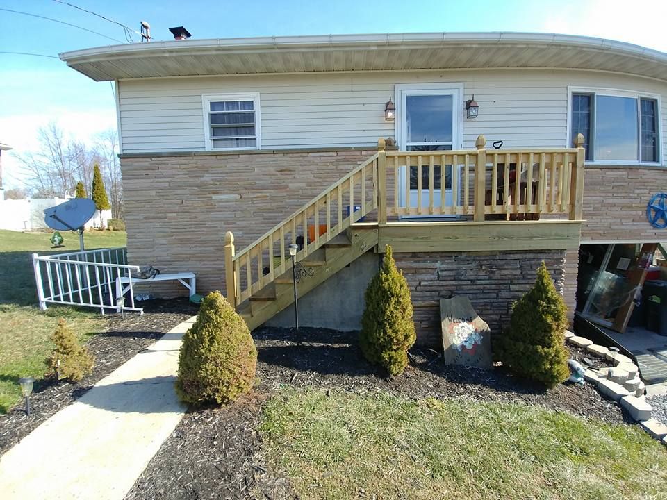 A house with a wooden deck and stairs leading up to it