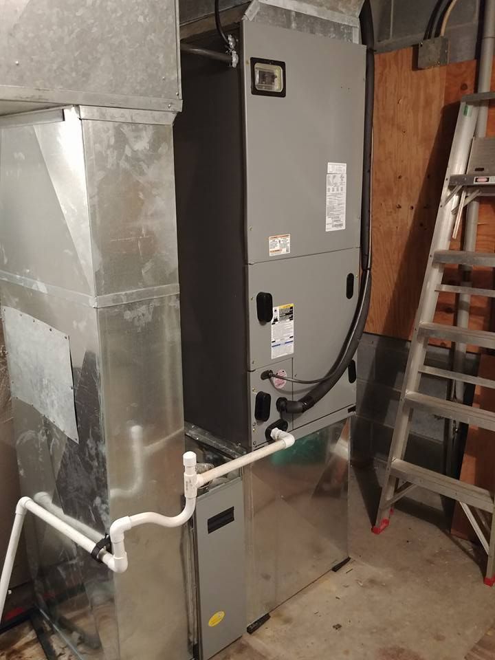 An air conditioner is sitting in a room next to a ladder.