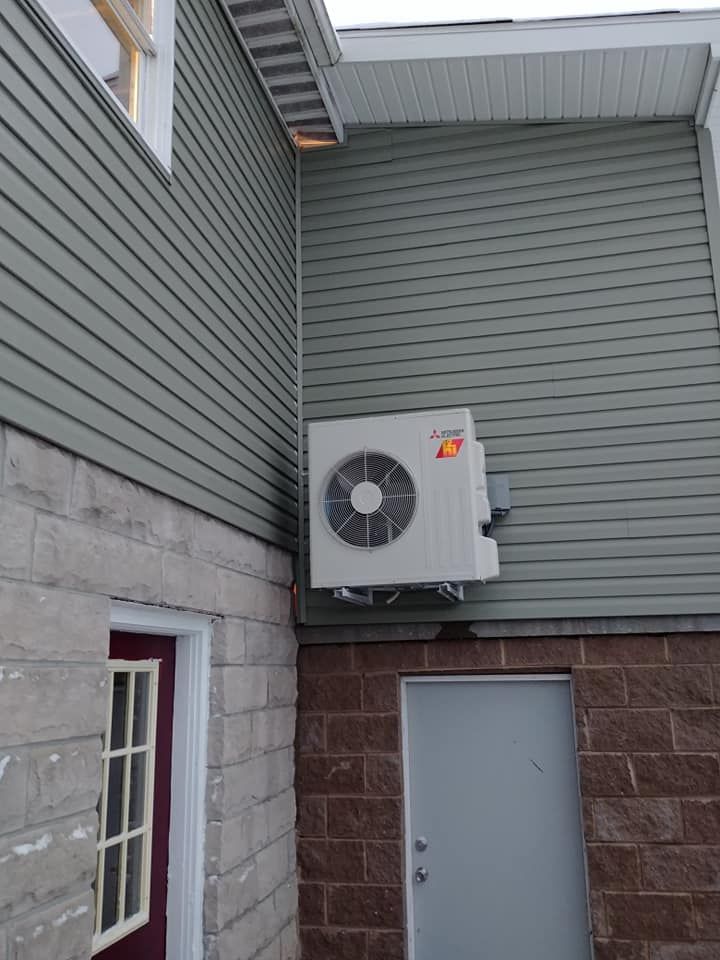 A white air conditioner is mounted on the side of a building
