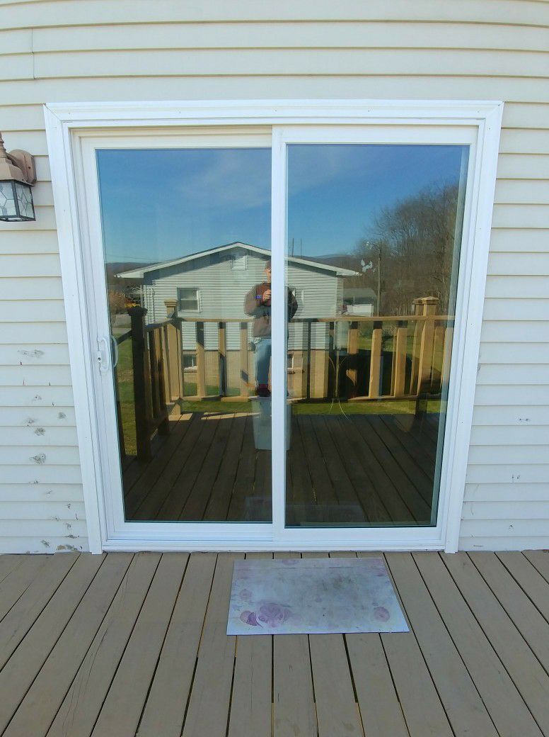 A white sliding glass door is open to a deck