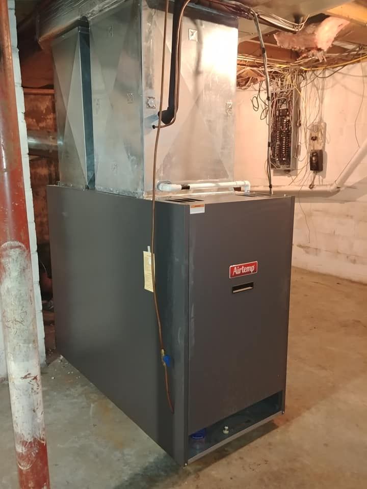 A large air conditioner is sitting in a basement next to a wall.