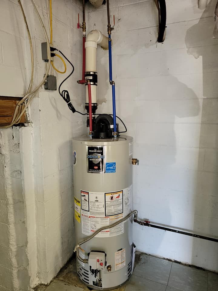A water heater is sitting in a room next to a wall.