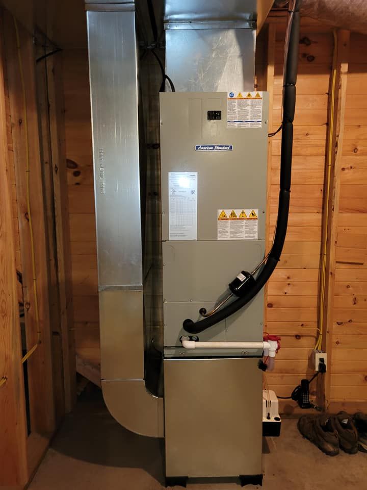 An air conditioner is sitting in a basement next to a wooden wall.